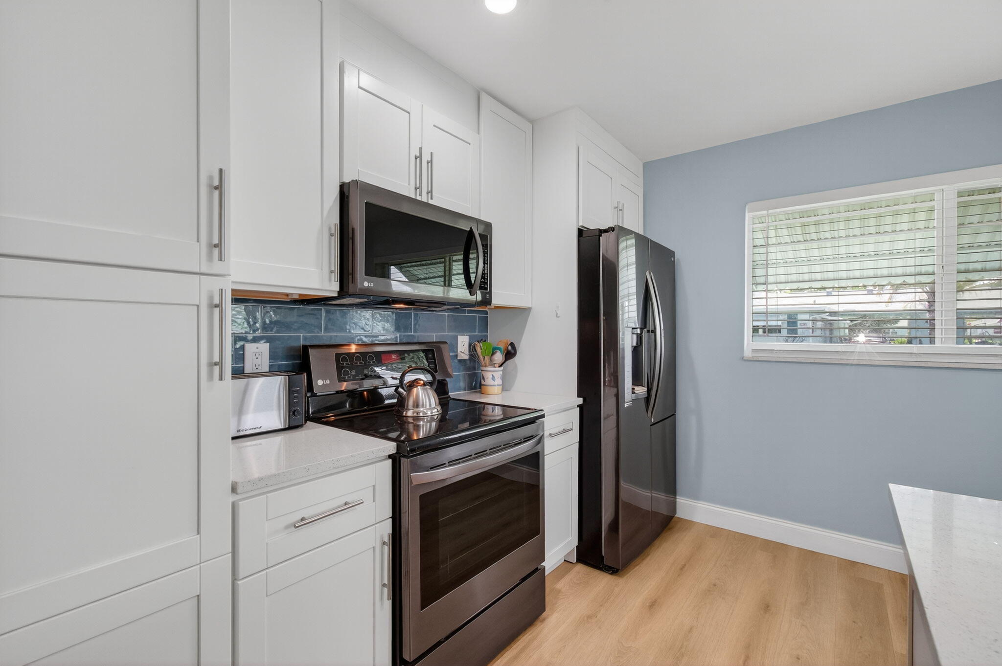 632 Hummingbird Lane Delray Beach, FL 33445 - Photo 18 of 60 a kitchen with a refrigerator stove and microwave