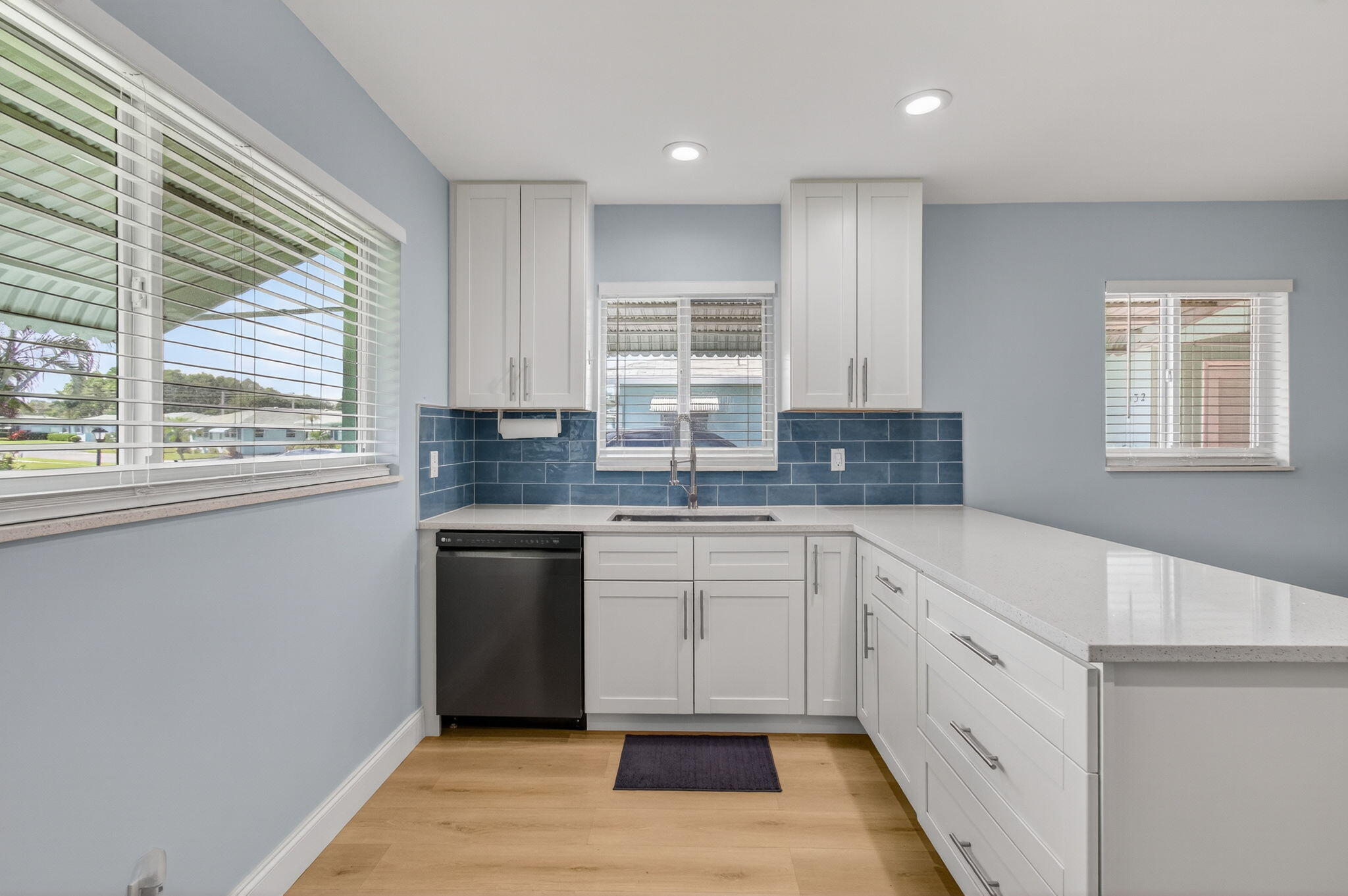 632 Hummingbird Lane Delray Beach, FL 33445 - Photo 20 of 60 a kitchen with granite countertop white cabinets white appliances a sink and a window
