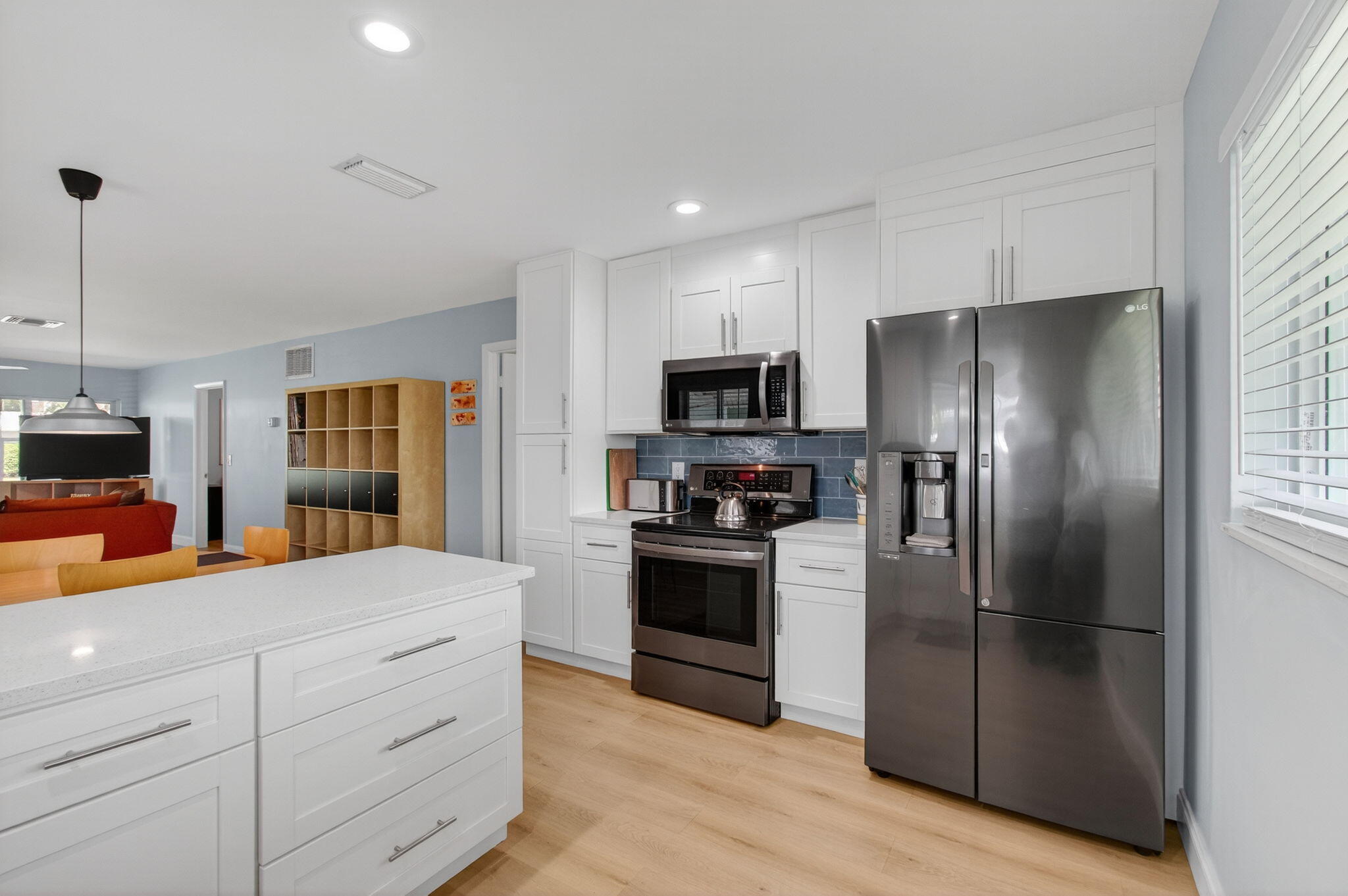 632 Hummingbird Lane Delray Beach, FL 33445 - Photo 22 of 60 a kitchen with stainless steel appliances kitchen island granite countertop a refrigerator and a stove top oven