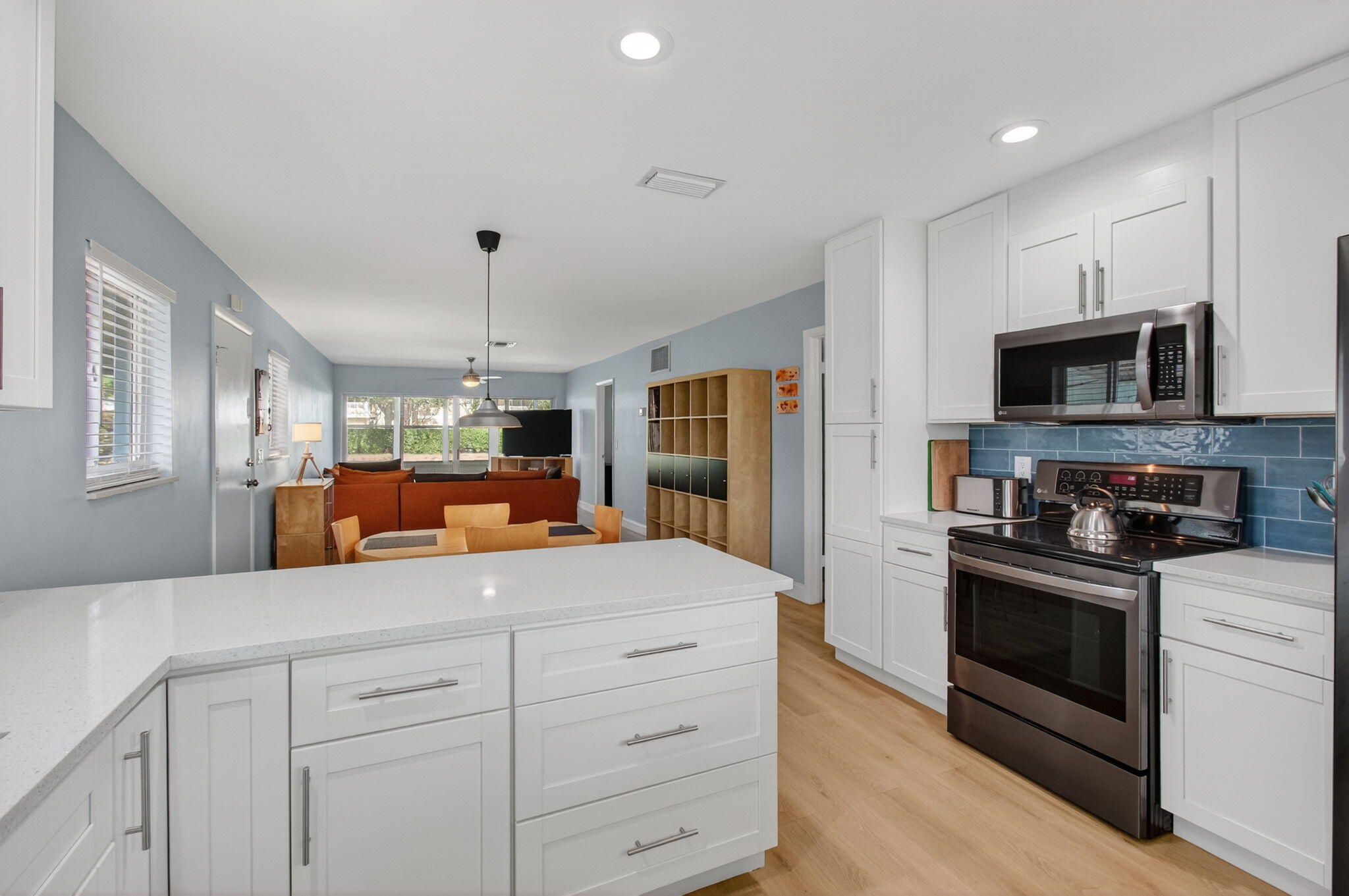 632 Hummingbird Lane Delray Beach, FL 33445 - Photo 24 of 60 a kitchen with kitchen island white cabinets and stainless steel appliances