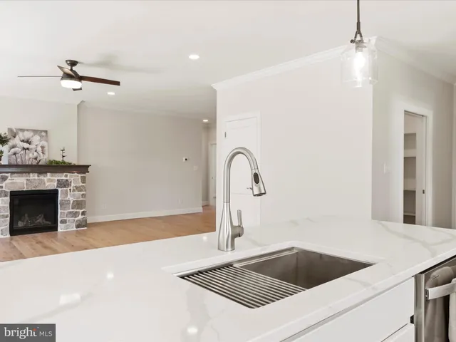 a view of an empty room with wooden floor and windows