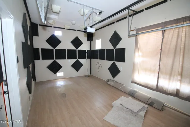 a view of an empty room with a window and chandelier