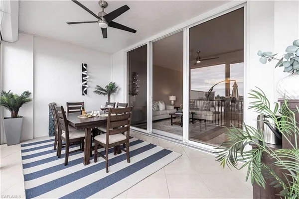 a dining room with furniture and floor to ceiling window