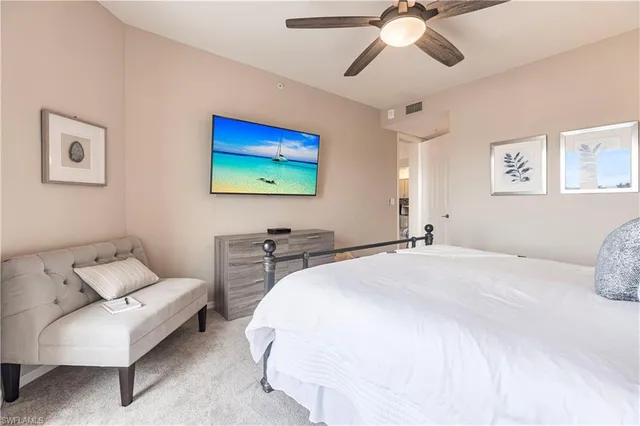 a spacious bedroom with a bed and a chandelier