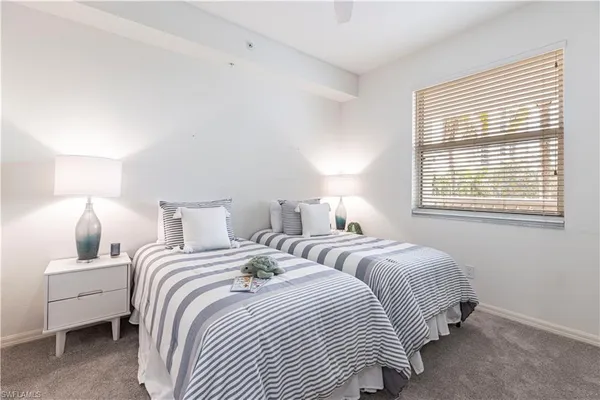 a bedroom with two beds and a lamp