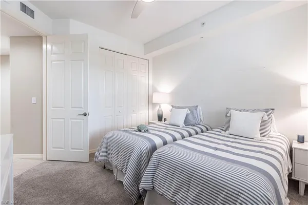 a bedroom with two beds and a closet