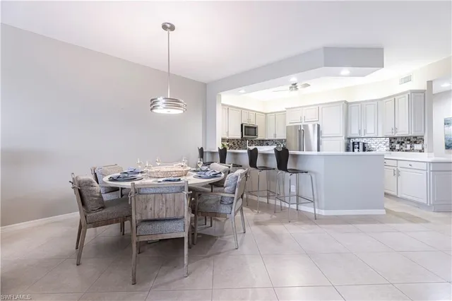 a view of a dining room and livingroom with furniture wooden floor a chandelier