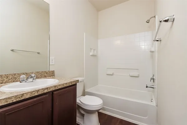 a bathroom with a granite countertop toilet a sink and a bathtub