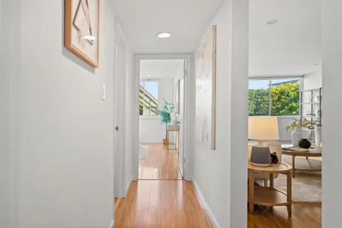 a view of living room with a large window and wooden floor