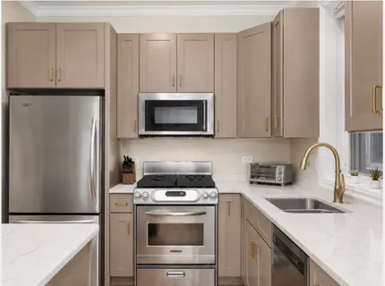 a kitchen with stainless steel appliances a stove a sink a refrigerator and cabinets