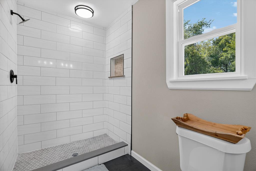130 R&R Drive Springtown, TX 76082 - Photo 32 of 40 Walk-in shower featuring white subway tile, a recessed niche, black fixtures, and a hex tile floor