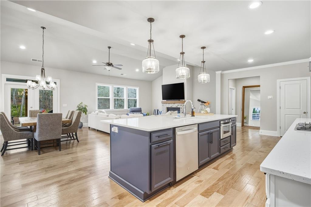 265 Fountain Oak Way Canton, GA 30114 - Photo 14 of 59 a large kitchen with kitchen island a stove a sink a dining table and chairs