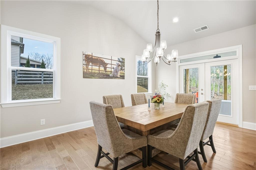 265 Fountain Oak Way Canton, GA 30114 - Photo 17 of 59 a dining room with wooden floor a chandelier a wooden table and chairs
