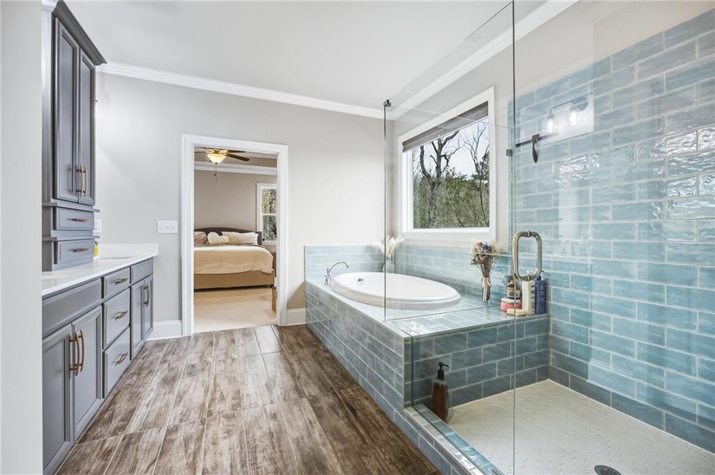 265 Fountain Oak Way Canton, GA 30114 - Photo 27 of 59 a spacious bathroom with a granite countertop tub sink a mirror and shower