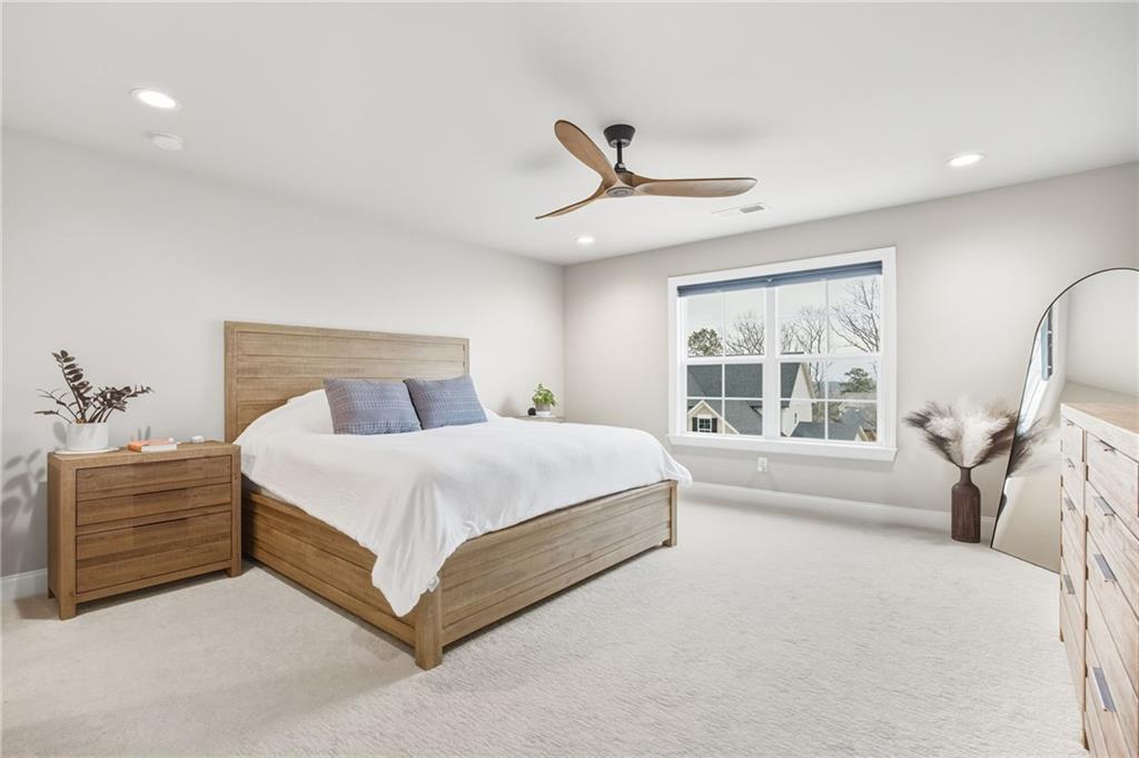 265 Fountain Oak Way Canton, GA 30114 - Photo 37 of 59 a bedroom with a large bed and a chandelier fan