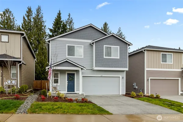 a front view of a house with a yard and garage