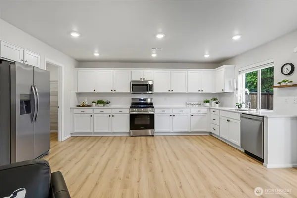 a kitchen with white cabinets and stainless steel appliances