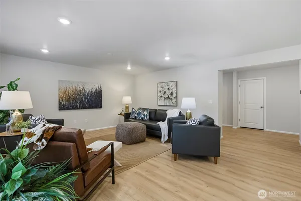 a living room with furniture and a wooden floor