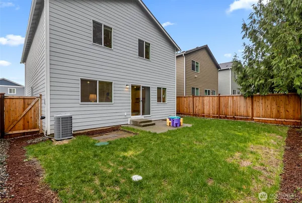 a view of backyard with wooden fence and a large tree