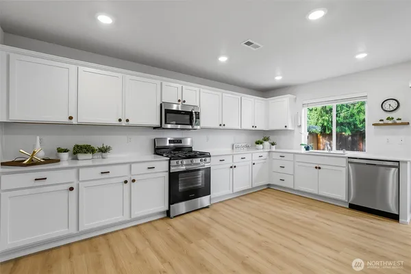 a kitchen with granite countertop white cabinets and white appliances