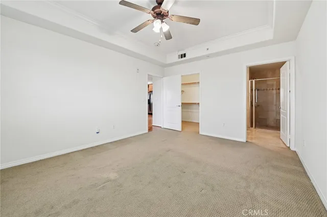 an empty room with chandelier fan and closet area