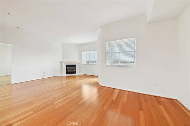 an empty room with wooden floor and a window