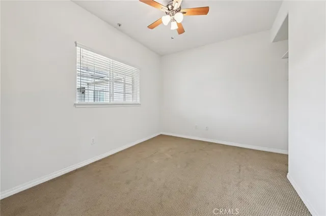 an empty room with a window and a fan