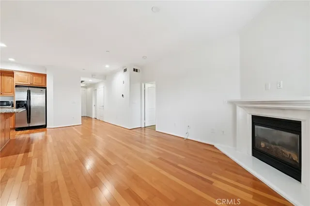 a view of empty room with wooden floor and fireplace