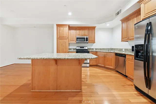a large kitchen with stainless steel appliances granite countertop a stove a sink and a refrigerator