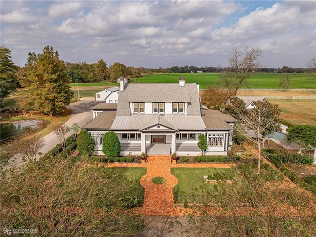 an aerial view of a house with a garden and lake view