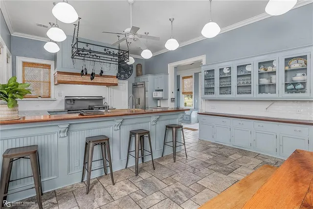 a kitchen with cabinets a sink and chairs