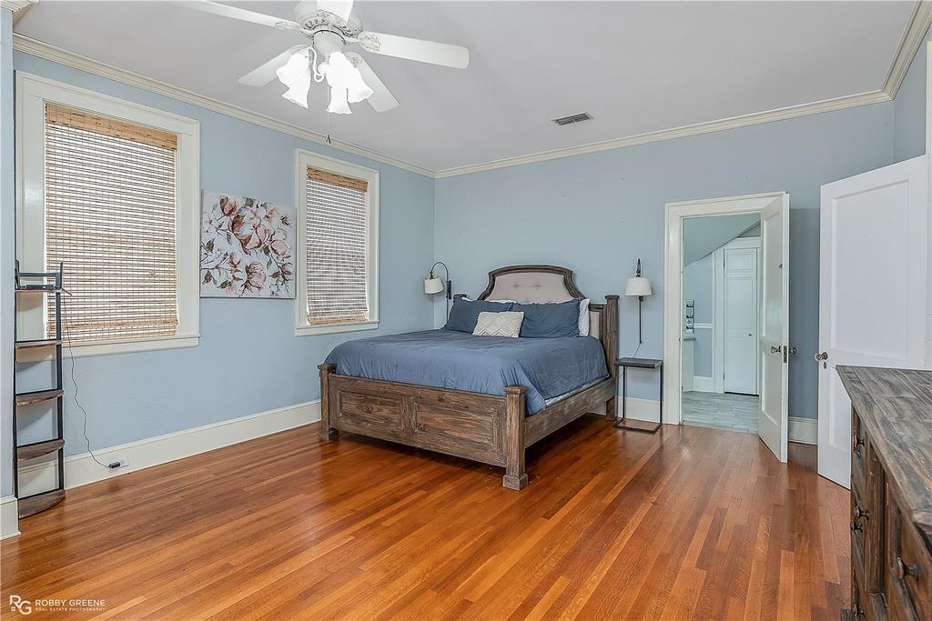 8265 Cornhusker Road Shreveport, LA 71107 - Photo 25 of 39 a bedroom with a bed and wooden floor