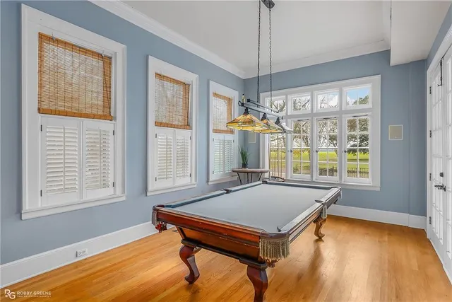 a room with pool table and windows