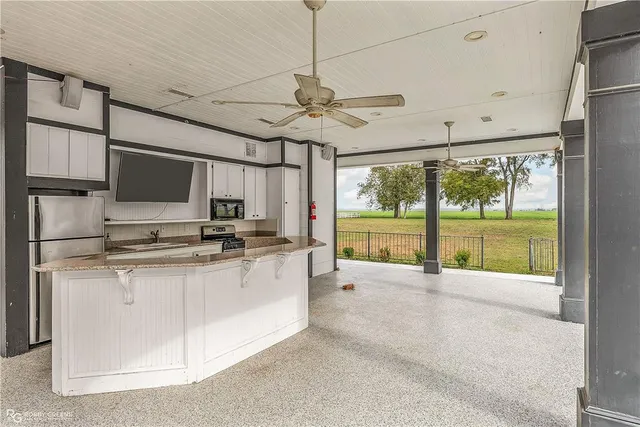 a large kitchen with stainless steel appliances granite countertop a stove and a refrigerator