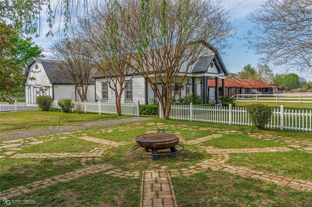 8265 Cornhusker Road Shreveport, LA 71107 - Photo 10 of 39 a front view of a house with a garden and trees