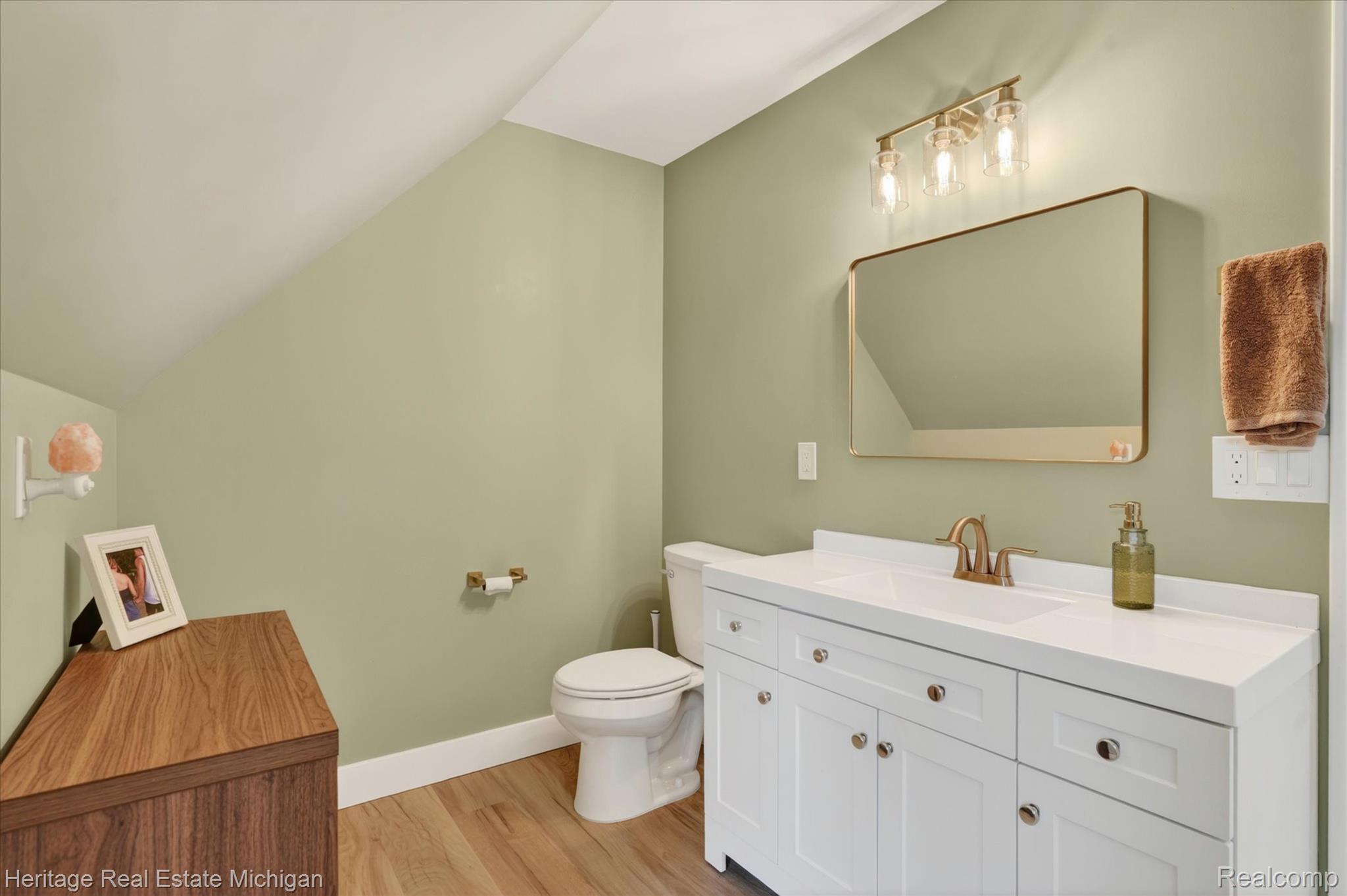 5835 Warner Road Fowlerville, MI 48836 - Photo 19 of 59 Half bathroom featuring vanity, vaulted ceiling, and light wood finished floors