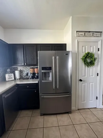 a kitchen with granite countertop a refrigerator and a sink