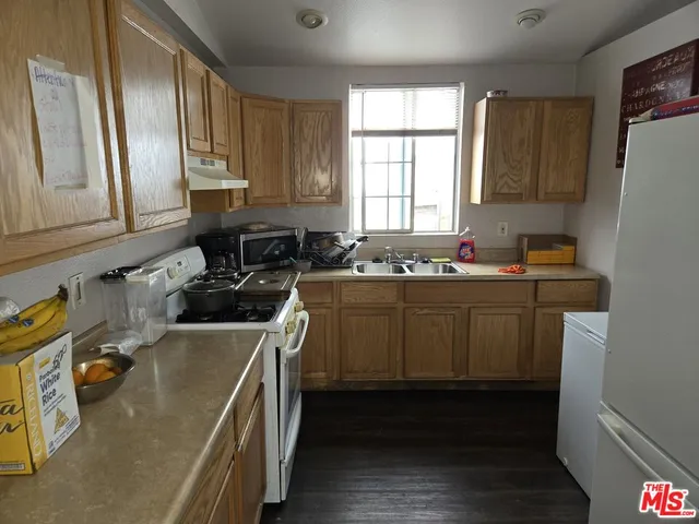 a kitchen with a sink a stove cabinets and wooden floor