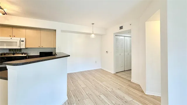 a kitchen with stainless steel appliances granite countertop a stove a sink and white cabinets