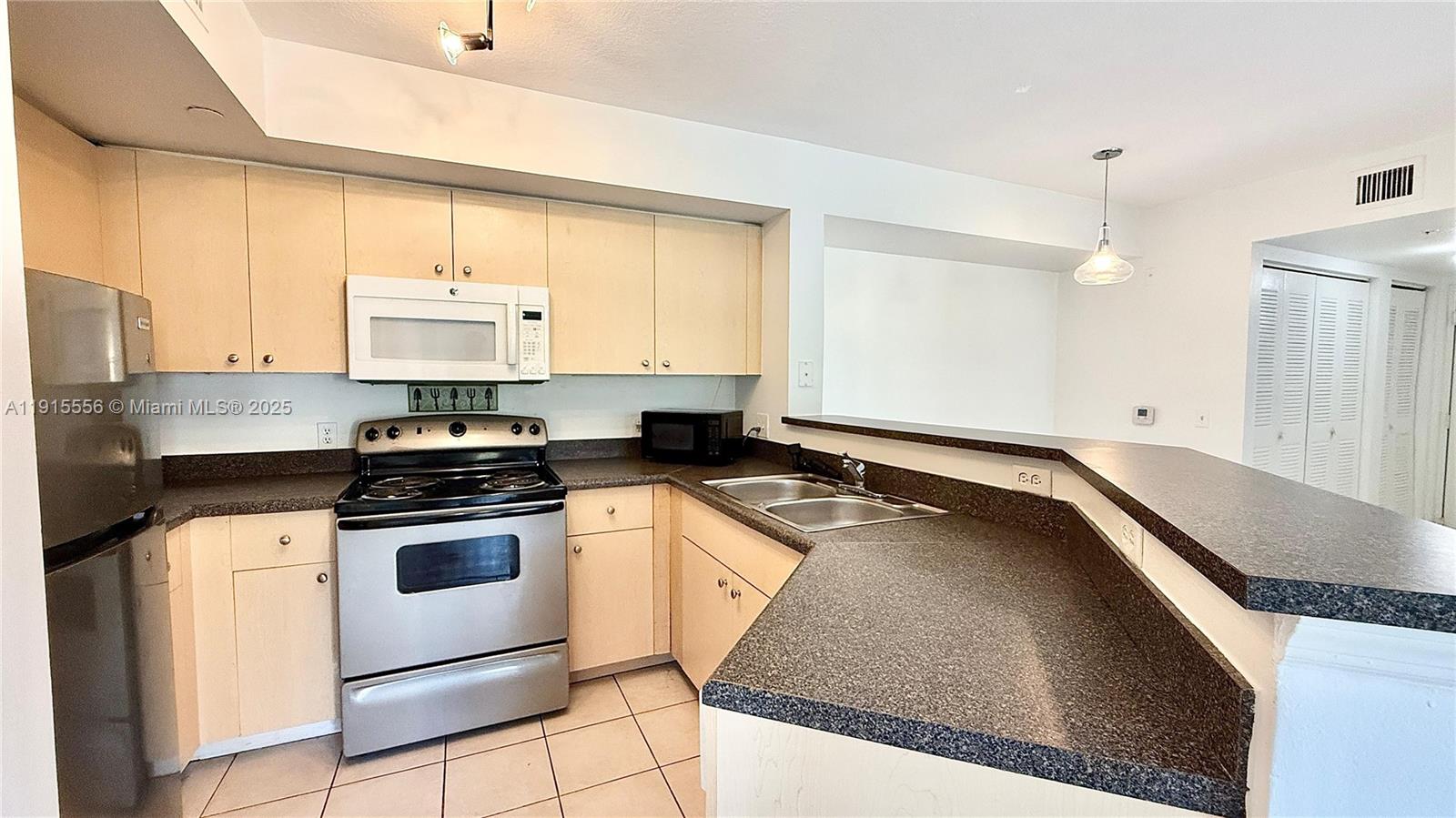 4190 San Marino Boulevard, Unit 102 West Palm Beach, FL 33409 - Photo 17 of 33 a kitchen with stainless steel appliances granite countertop a stove a sink and white cabinets