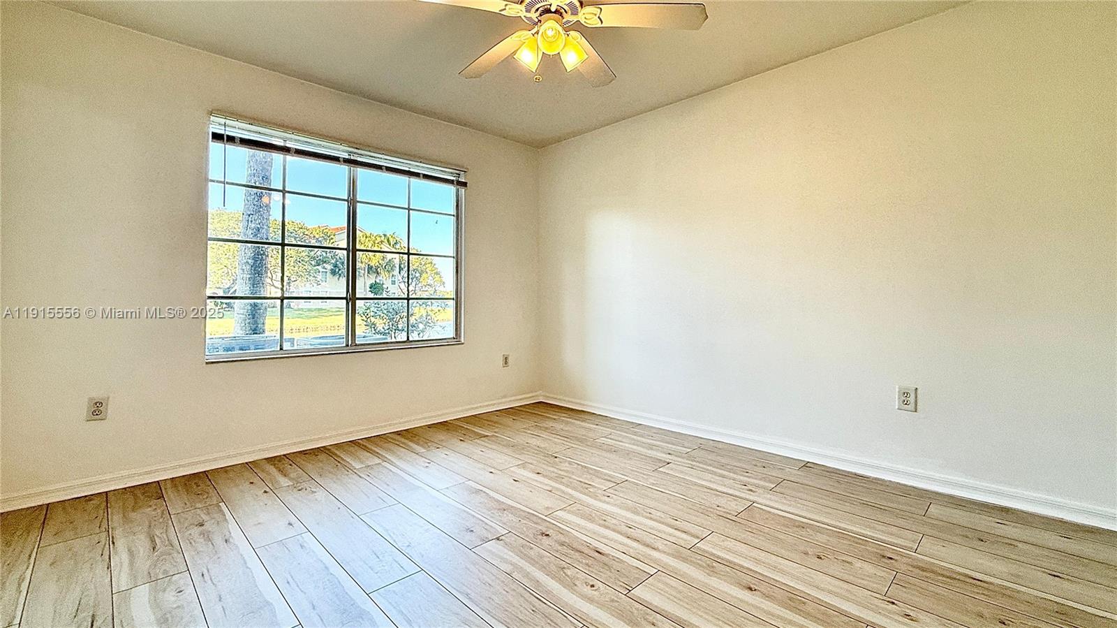4190 San Marino Boulevard, Unit 102 West Palm Beach, FL 33409 - Photo 19 of 33 an empty room with wooden floor and windows