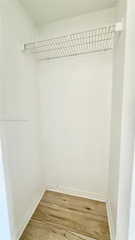 a view of a hallway with an empty room and chandelier fan