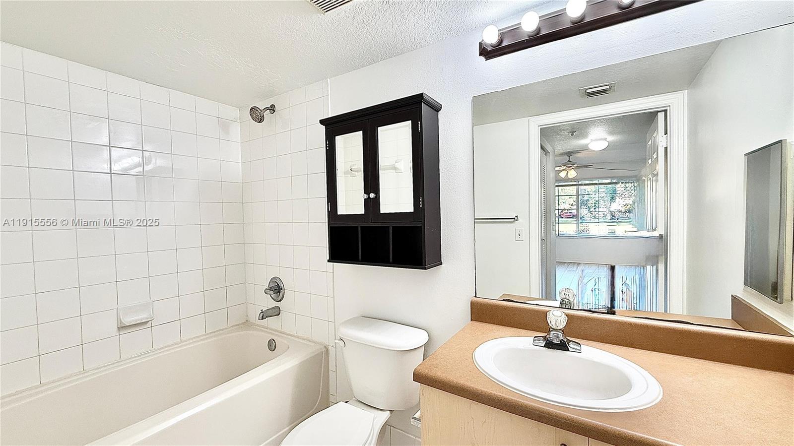 4190 San Marino Boulevard, Unit 102 West Palm Beach, FL 33409 - Photo 26 of 33 a bathroom with a bathtub shower sink and mirror