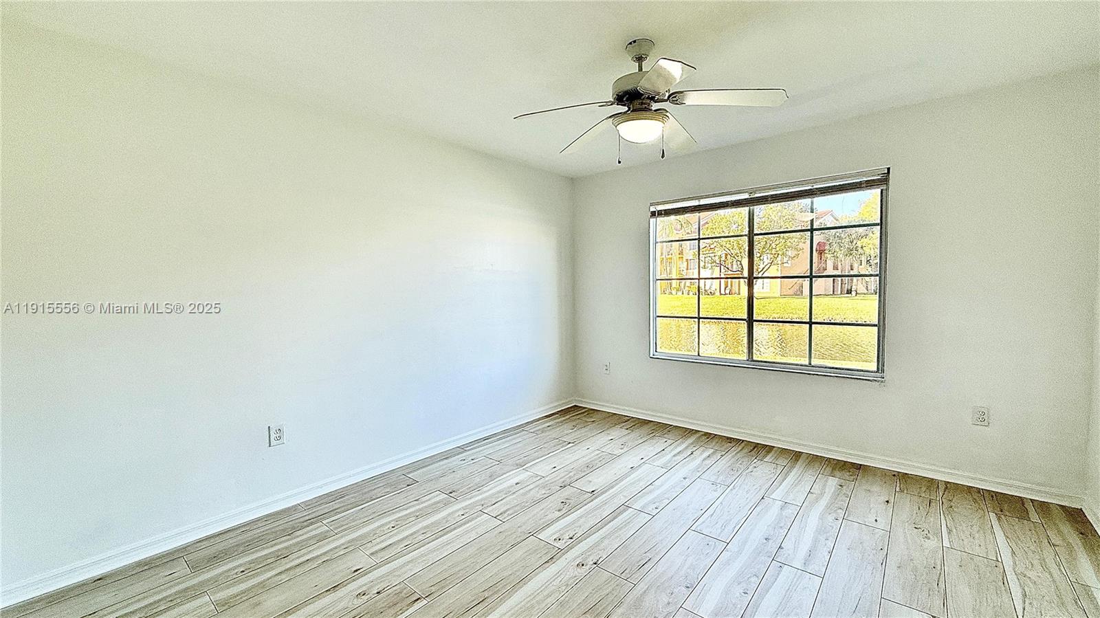 4190 San Marino Boulevard, Unit 102 West Palm Beach, FL 33409 - Photo 27 of 33 a view of an empty room with wooden floor and a window