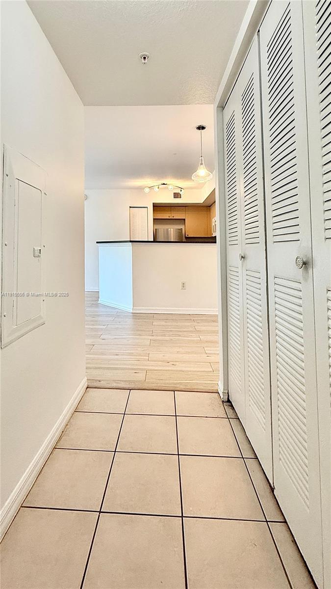 4190 San Marino Boulevard, Unit 102 West Palm Beach, FL 33409 - Photo 3 of 33 a view of a refrigerator and an empty room with wooden floor