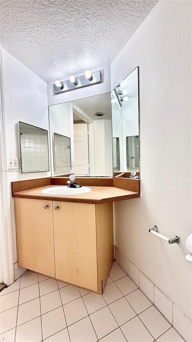 4190 San Marino Boulevard, Unit 102 West Palm Beach, FL 33409 - Photo 32 of 33 a bathroom with a sink and a mirror