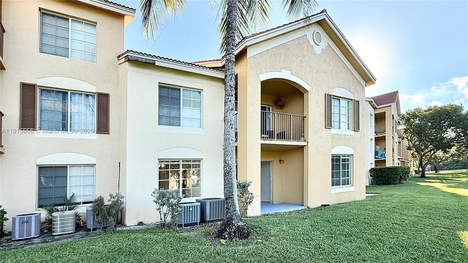 4190 San Marino Boulevard, Unit 102 West Palm Beach, FL 33409 - Photo 10 of 33 a view of a white house with many windows and a yard