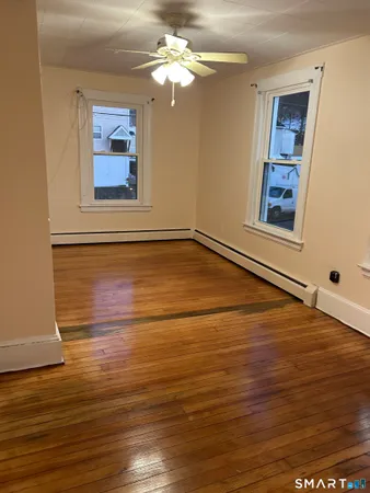 a view of an empty room with wooden floor