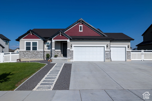 Cleanly landscaped craftsmen style rambler home featuring a combination of stucco, stone, and hardie-side exterior finishes, a 3-car garage, and RV parking