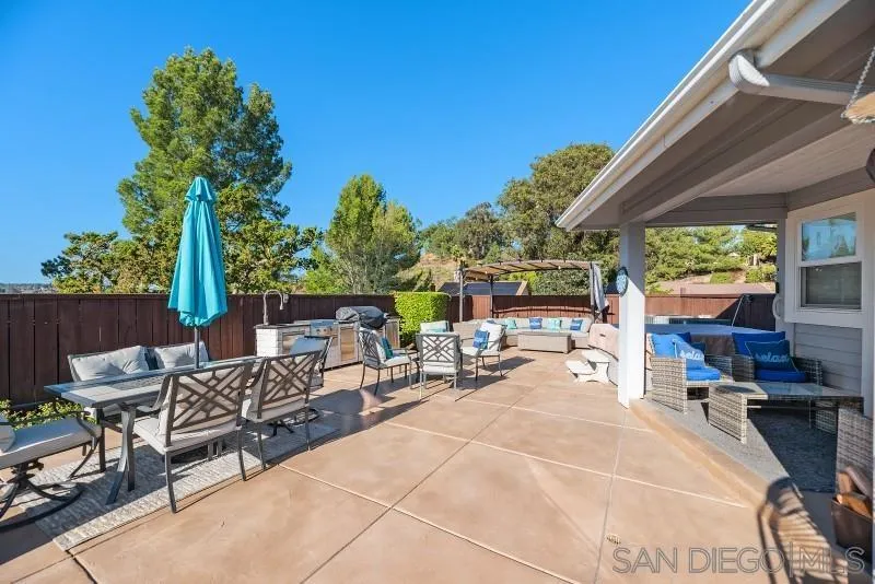 12750 McFeron Road Poway, CA 92064 - Photo 42 of 51 a view of a patio with a table and chairs under an umbrella with a small yard